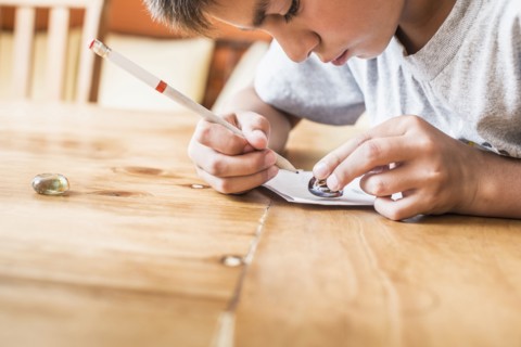Mixed race boy coloring at desk