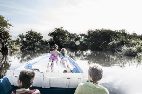 Children riding in canoe on rural lake