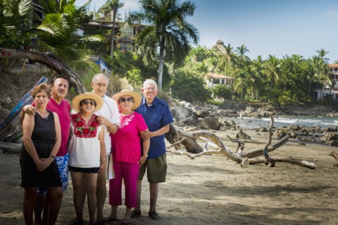 Hispanic friends smiling together on beach