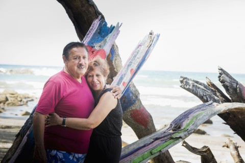 Hispanic couple hugging on beach