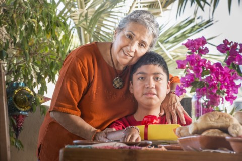 Older Hispanic woman hugging grandson