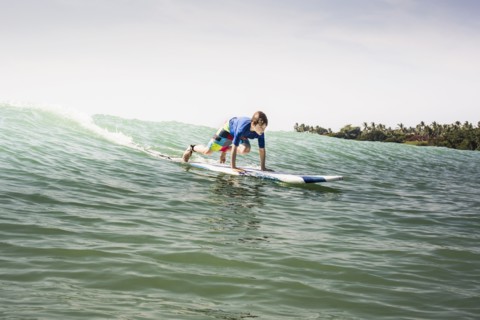 Caucasian boy surfing in ocean