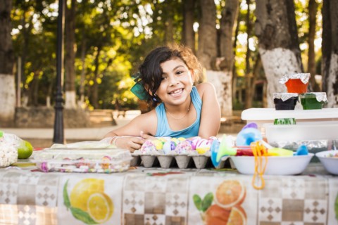 Hispanic girl smiling with Easter eggs