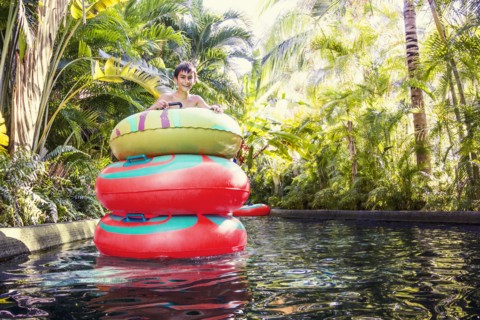 Mixed race boy playing in stacked inner tubes in pool