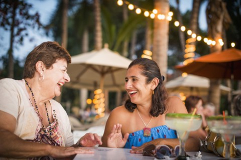 Mother and daughter laughing at outdoor table