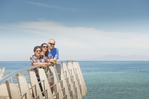Family smiling together at waterfront railing