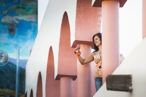 Low angle view of Hispanic woman taking photograph