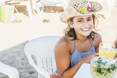Mixed race girl wearing cowboy hat at table