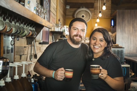 Hispanic couple working in coffee shop