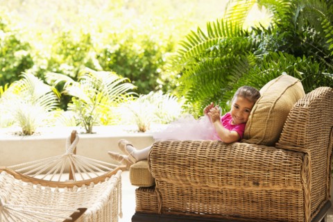 Hispanic girl sitting in armchair outdoors