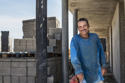Hispanic construction worker smiling at construction site