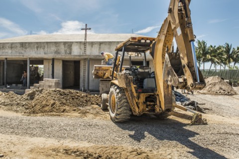 Hispanic construction worker on bulldozer at construction site