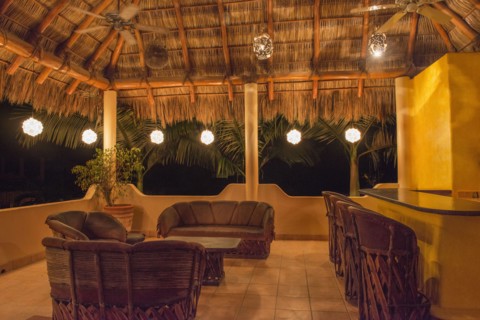 Sofas and chairs with bar on outdoor patio at night