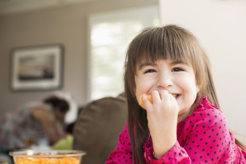 Smiling Hispanic girl eating fruit