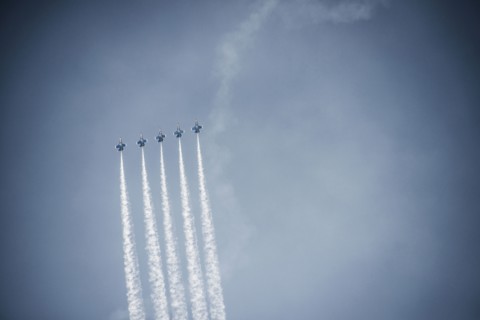 Jets flying in formation in cloudy blue sky