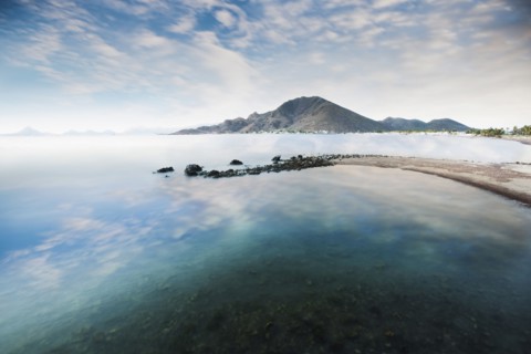 Cloudy blue sky reflecting in lake