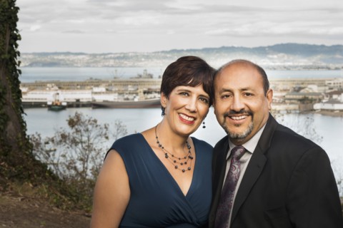 Hispanic couple hugging in formal wear