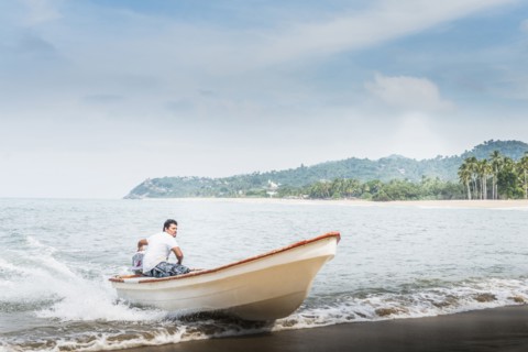 Man steering boat onto beach