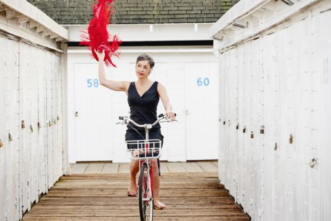 Older Caucasian woman riding bicycle on wooden dock