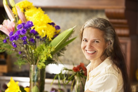 Hispanic woman with flowers in kitchen