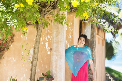 Hispanic woman smiling outside house