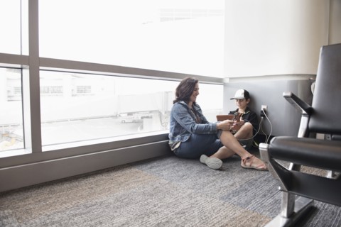 Mother and son using digital tablet in airport