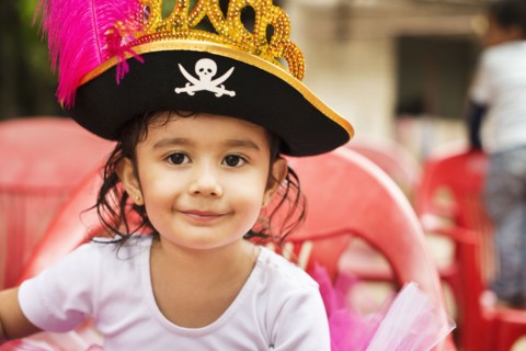 Hispanic girl wearing pirate hat at party