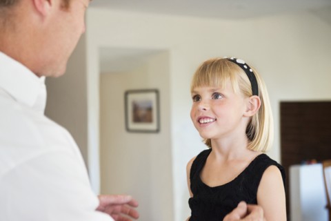 Caucasian father and daughter talking in living room