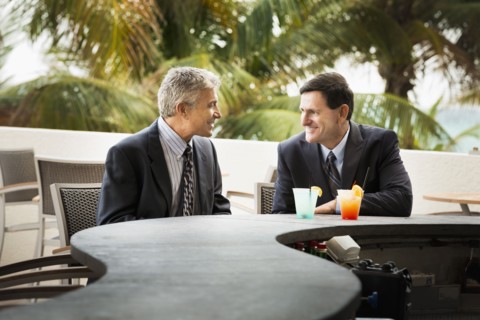 Caucasian businessmen with cocktails at patio bar