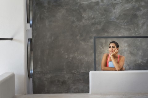 Hispanic woman sitting in modern living room