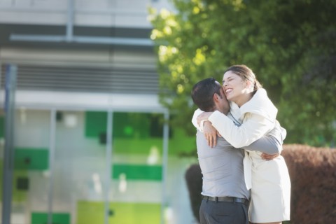 Hispanic couple hugging in city