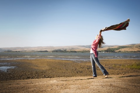 Caucasian woman holding blanket in wind