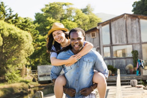 Man carrying girlfriend piggyback outdoors