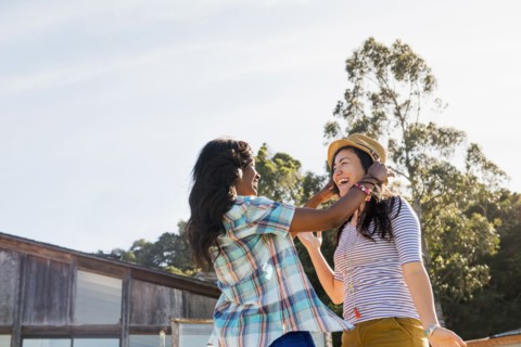 Women trying on hat outdoors