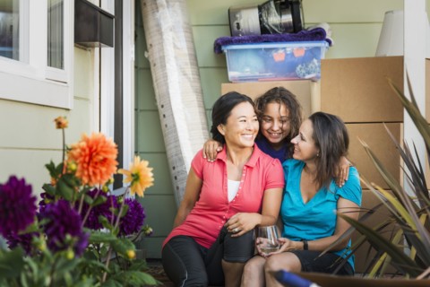 Family hugging outside house