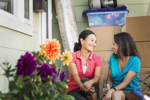 Women smiling outside house
