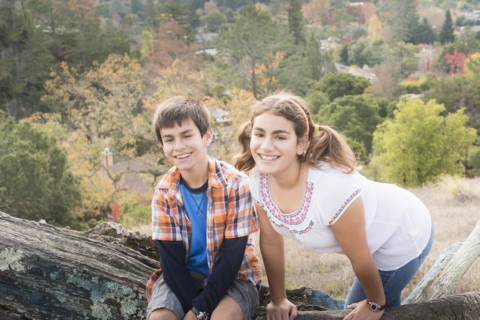 Mixed Race brother and sister posing on log