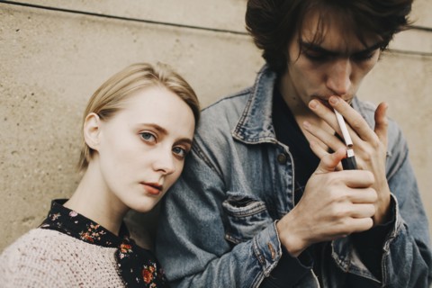 Caucasian man lighting cigarette near woman