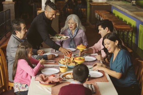 Waiter serving food to family in restaurant