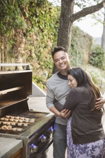 Expectant mother hugging husband near grille