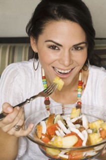 Hispanic woman eating healthy salad