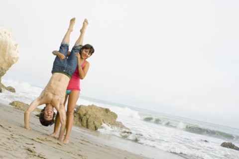 Woman supporting boyfriend doing handstand