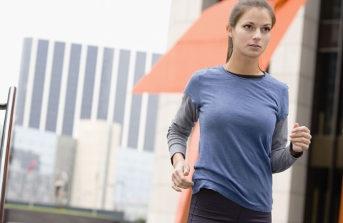 Hispanic woman running in urban area