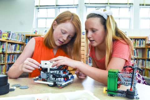 Girls assembling plastic blocks in library