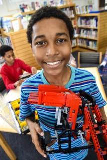 Boy posing with plastic blocks in library