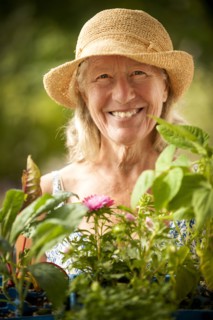 Portrait of smiling Caucasian woman holding tray of flowers