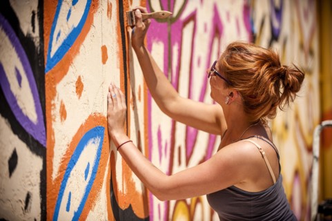 Caucasian woman painting mural on wall