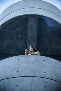 Low angle view of businesswoman on balcony texting on cell phone