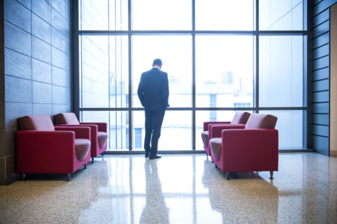 Hispanic businessman waiting in office lounge near window