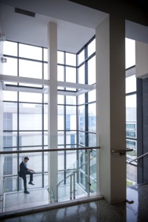 Hispanic businessman sitting on staircase railing near window